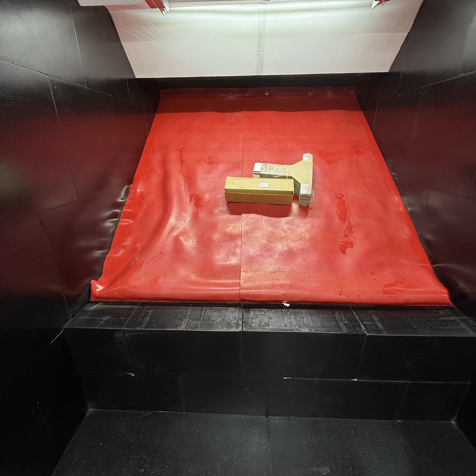 Sloped rubber bullet trap