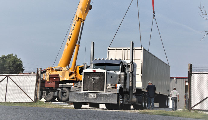 Industrial crane hoisting a containerized tactical training system