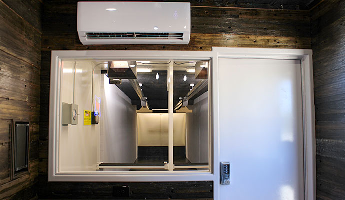 Interior viewing window and access door to indoor shooting range lanes