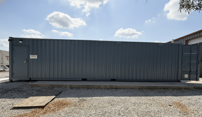 Side view of a dark grey mobile gun range container featuring a secure personnel entry door.