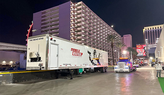 Road King mobile shooting range trailer hitched to semi-truck at outdoor location